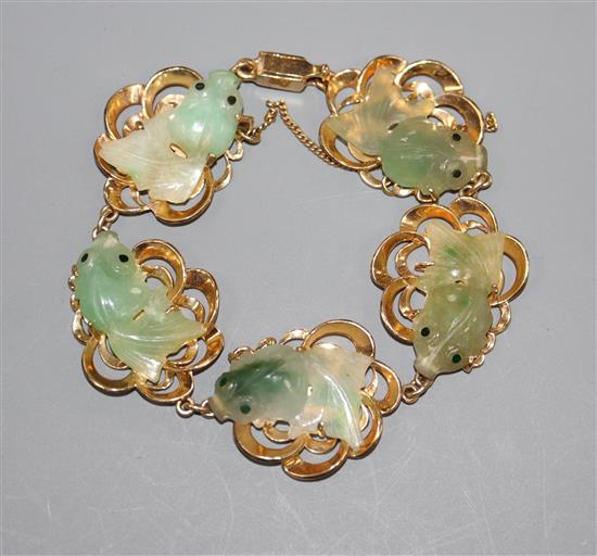 A 14k yellow metal and jade bracelet, each link mounted with jade carved as goldfish.